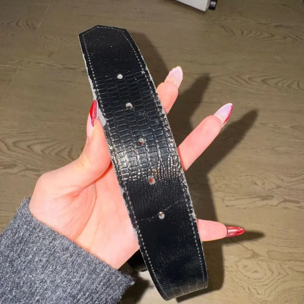 black patent leather belt with a large gold buckle, possibly a vintage 80's styl
